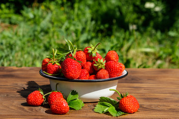 Fresh ripe strawberry on a wooden table outdoor