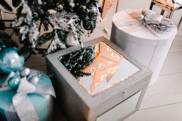 Decorated Christmas interior. Fir-tree decorated garlands with gifts boxes in a white room. Decor. Happy New Year and Merry Christmas. The concept of winter holiday.