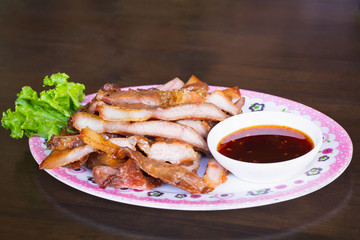 Charcoal-boiled pork neck,Grill pork on wooren table.Eaten with dipping sauce.Thai food