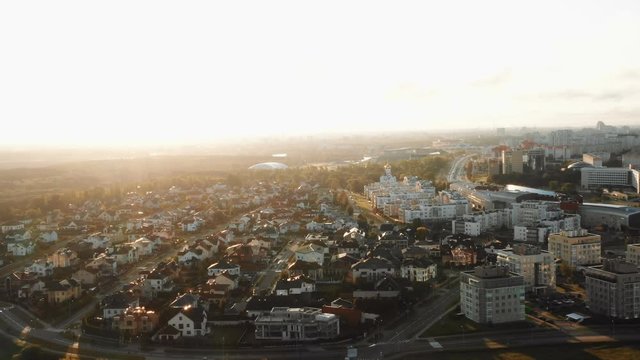 Drone flying above inner suburb house district, city buildings and parks panorama in Minsk, Belarus during sunrise.