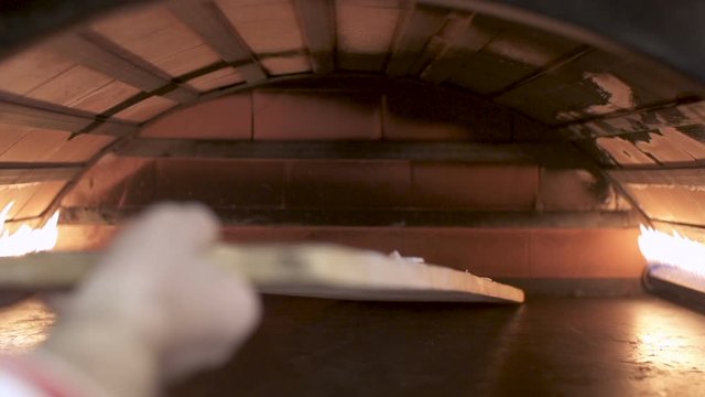 Making Manakeesh inside a gas heated oven, slow motion. Manakeesh is a type of pastry, which is a popular Lebanese and Levantine food consisting of dough topped with thyme, cheese or meat