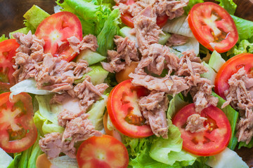 Top view tuna salad with red raw tomato, fresh lettuce. Hight vitamins and low fat for loose weight. Heathy food concept.