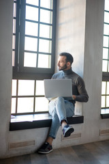 Bearded man working remotely on his laptop