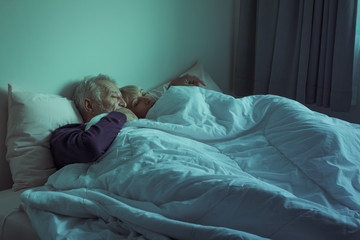  elderly couple caucasian senior man and woman sleeping and rest together in white blanket in bedroom, retirement health care with love lifestyle concept