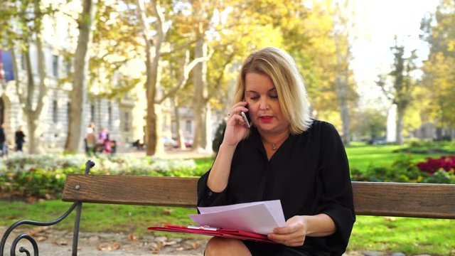 Image of business woman analysing reports at public park