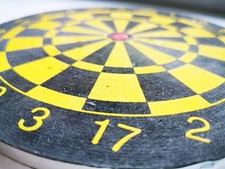 Target for throwing Darts. Black and yellow concentric circles with digital markings and dart marks