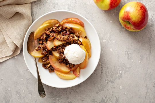 Healthy gluten free apple crisp or crumble with cinnamon and pecans topped with a scoop of ice cream