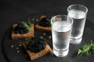Cold Russian vodka and sandwiches with black caviar on table, closeup - obrazy, fototapety, plakaty