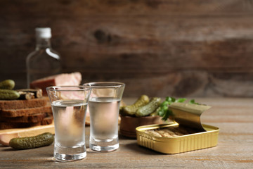 Cold Russian vodka with snacks on wooden table
