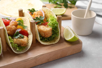 Yummy fish tacos served on marble table, closeup