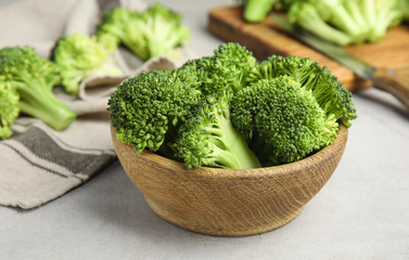 Fresh green broccoli in wooden bowl on light table