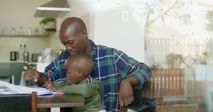 Dad teaching son how to draw, candid moment family at home spending quality time together
