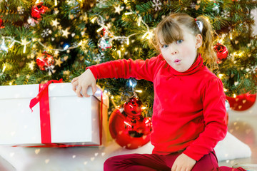 beautiful girl opening her christmas presents