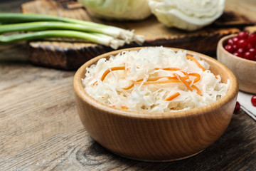 Tasty fermented cabbage on wooden table, closeup