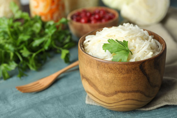 Tasty fermented cabbage on blue wooden table, closeup