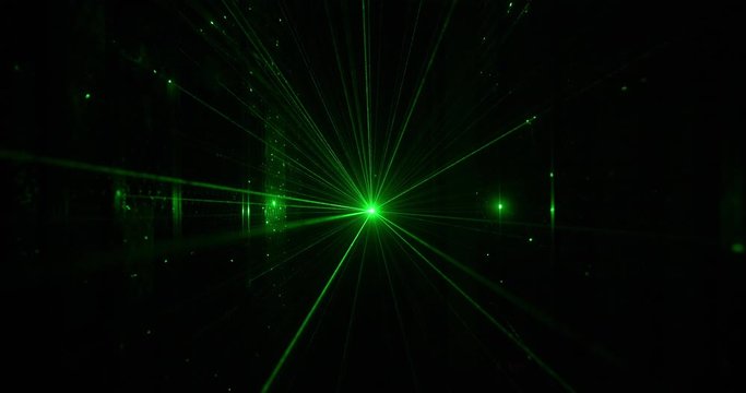 Nightclub laser with green rays in motion at party