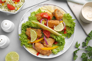Delicious fish tacos served on light  grey table, flat lay