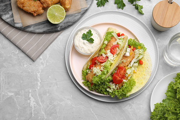 Delicious fish tacos served on grey marble table, flat lay