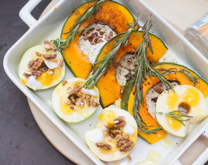 Easy dinner: pumpkin with herbs, apples and nuts before baking.