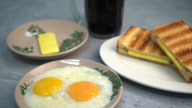 Asian traditional breakfast combination of half boiled eggs, toast bread with butter and kaya and coffee