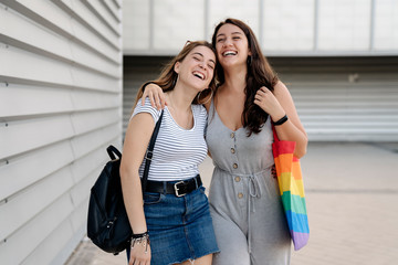 Pretty young couple of girls walking together and having fun in the street