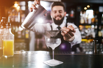 Professional bartender is making cocktail at night club