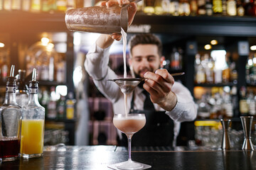 Professional bartender is making cocktail at night club