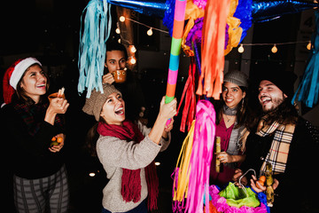 Mexican People breaking a piñata celebrating a Posada in Christmas Mexico