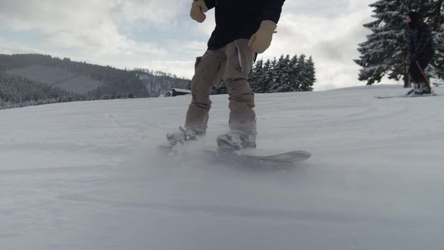Snowboardfahrer im Tiefschnee auf einer Piste in einem Skigebiet an einem Bedeckten tag 