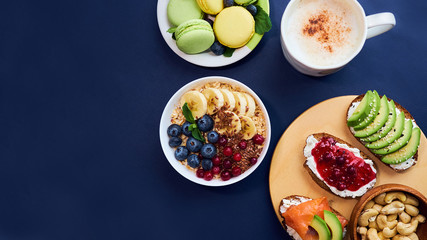 breakfast top view black background. oatmeal with berries, toasts on a wooden tray, nuts, coffee