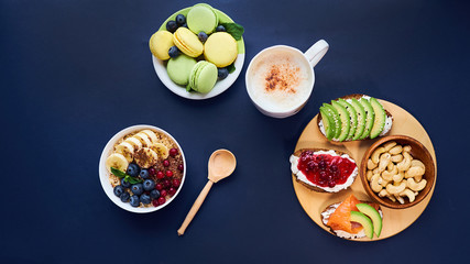 breakfast top view black background. oatmeal with berries, toasts on a wooden tray, nuts, coffee