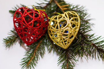 Green spruce branch with glitter decorations in the corner close up on white background