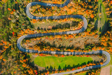 Beautiful aerial landscape of mountain forest road. Aerial view of curvy road in beautiful autumn forest