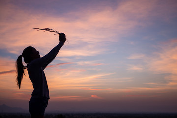 Fototapeta premium Happiness woman stay outdoor under sunlight of sunset,hold her flower.