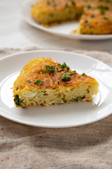 Homemade spaghetti omelette on a white plate, side view. Close-up.