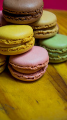 Colored macarons isolated on wooden dish, typical French dish