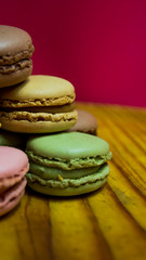 Colored macarons isolated on wooden dish, typical French dish