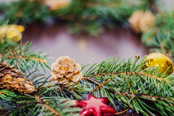 Green fir branches closeup on brown wooden background with decorations