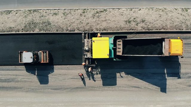 Industrial machine is paving asphalt in a top view