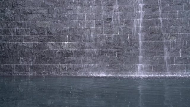 waterfall on black stone brick wall background