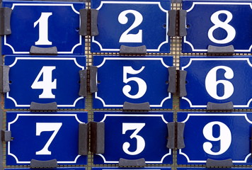 Plaques de numéros de rue blanches et bleues.