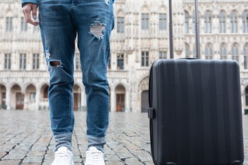 Woman tourist goes with a suitcase at the Grand Place in Brussels, Belgium