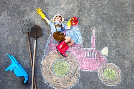 little kid boy having fun with tractor chalks picture