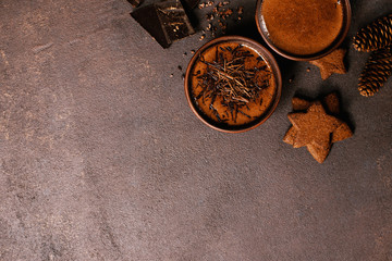 Brown textured background with two cups of hot chocolate or cocoa drink