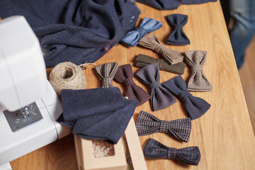 Bow ties made of wool on oak wooden table, adds a finished product. Small craft production