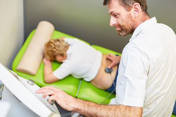 Obraz premium Doctor as orthopedist treats patient with stimulation current