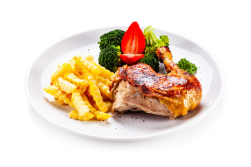 Grilled chicken leg with chips and vegetables on white background