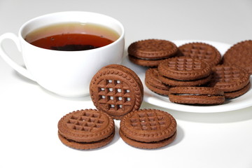 Cookies with chocolate. White cup with black tea. Tea ceremony. Sweet morning. Still life.