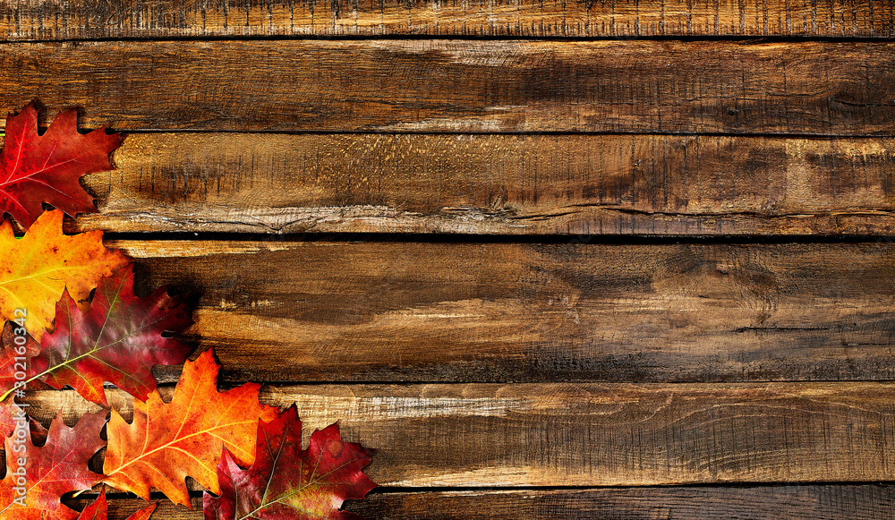 Wall mural autumn maple leaves on top view wooden table. horizontal frame with left corner bottom.