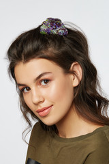Closeup half-turn face portrait of girl with dark wavy hair, wearing khaki t-shirt. Her hair is...